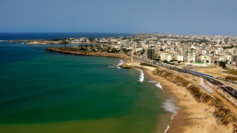 vue aérienne d'une plage animée longeant une ville côtière avec immeubles et voies ferrées