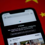 Close-up of a smartphone with TikTok app displayed against a China flag backdrop, highlighting solidarity message.