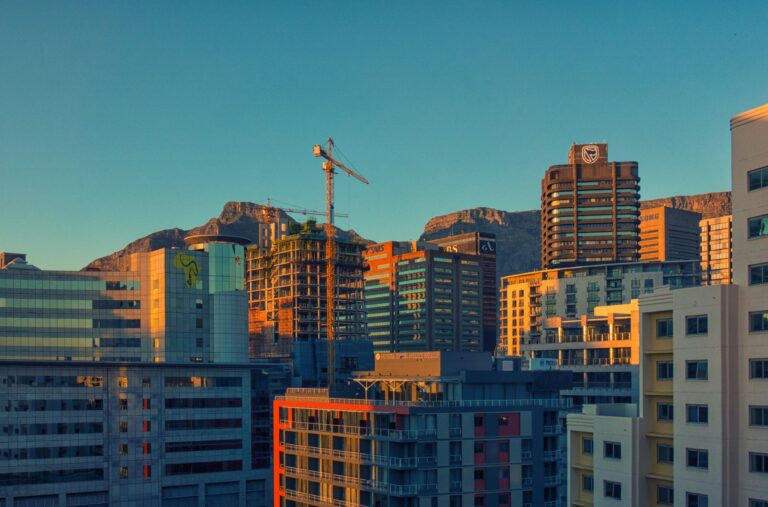 skyline urbain avec immeubles modernes et montagne en arrière-plan au coucher du soleil