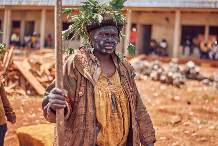 A tribal member in traditional attire and face paint during a ritual in Cameroon.